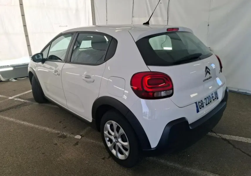 Citroën C3 blanche vue 3/4 arrière droit, avec enjoliveurs 15 pouces et protections noires sur ailes et bas de caisse.