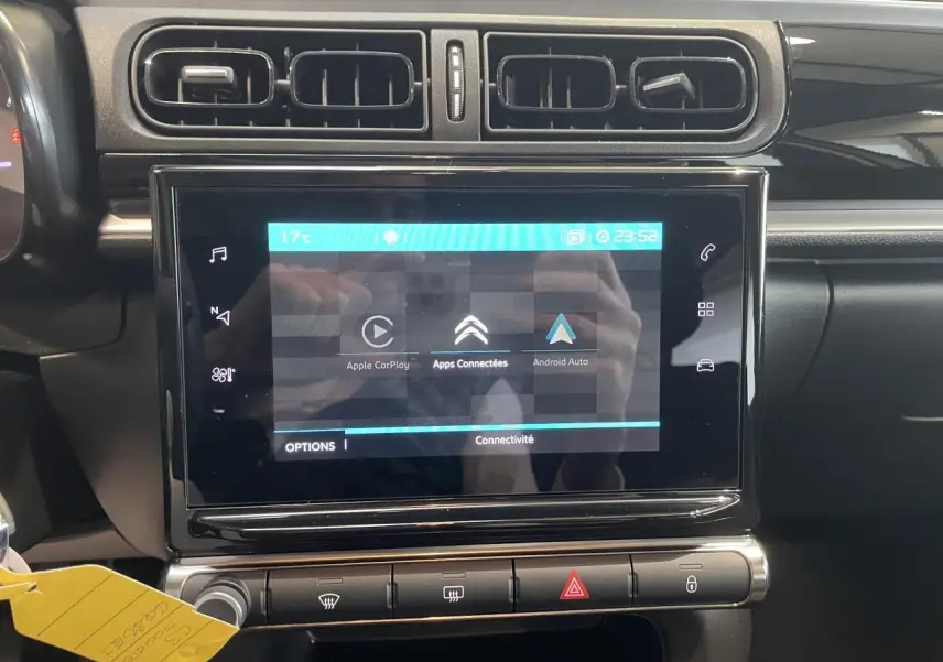 Vue rapprochée de la console centrale noire brillante avec écran tactile affichant Apple CarPlay et Android Auto sur Citroën C3 2023.