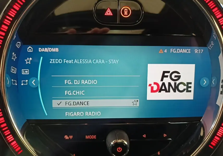 Écran central tactile de la MINI Cooper Edition Premium Plus noir, affichant la radio FG.DANCE avec éclairage LED rouge circulaire.