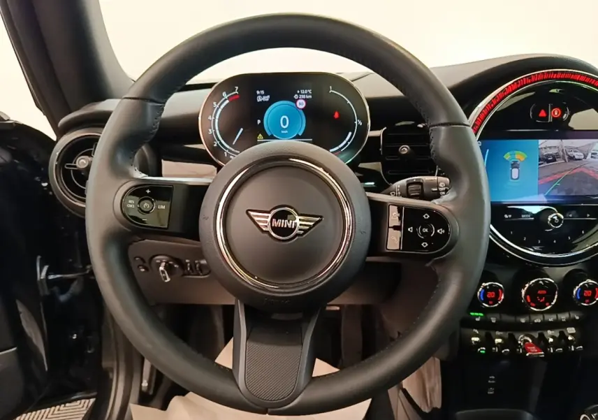 Vue intérieure centrée sur le volant cuir noir et le combiné d'instruments digital d'une MINI Cooper 2023.