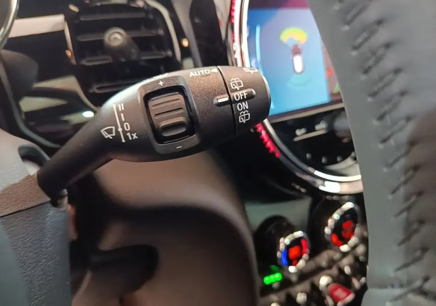 Gros plan sur la commande d’essuie-glace à gauche du volant dans l’habitacle noir d’une MINI Cooper 2023.