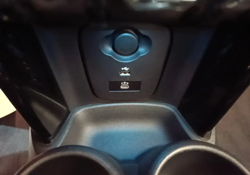 Vue rapprochée de la console centrale noire de la MINI Cooper Edition Premium Plus avec ports USB et prise 12V.