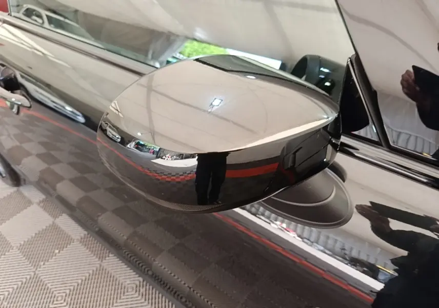 Gros plan sur le rétroviseur côté gauche noir brillant d'une MINI Cooper Edition Premium Plus 2023.