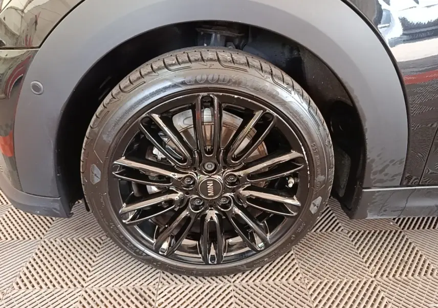 Gros plan sur la roue avant droite noire brillante d'une MINI Cooper Edition Premium Plus 2023 avec jante noire multi-branches.