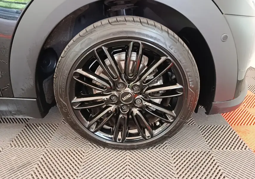 Gros plan sur la roue avant gauche noire brillante d'une MINI Cooper Edition Premium Plus 2023, jante multi-branches.