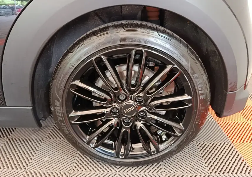 Gros plan sur la roue avant droite noire brillante d'une MINI Cooper Edition Premium Plus 2023.