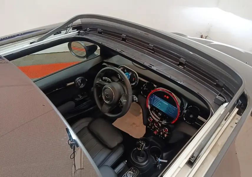 Vue intérieure plongeante du poste de conduite noir d'une MINI Cooper Edition Premium Plus 2023 avec toit ouvrant en verre.
