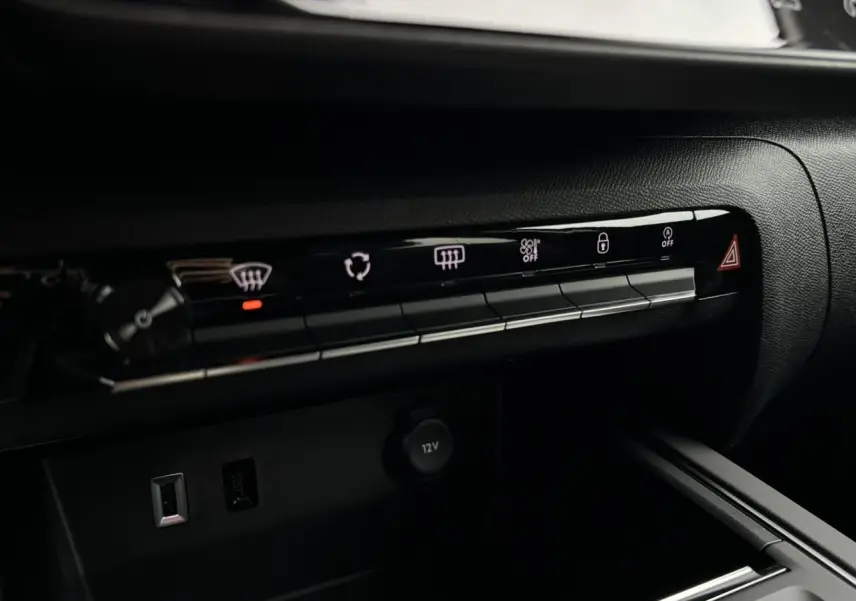 Gros plan sur la console centrale noire du Citroën C5 Aircross 2025 montrant les commandes climatisation et prises USB.