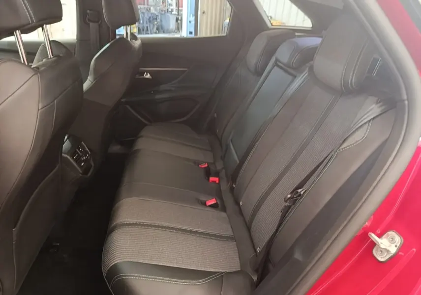 Vue intérieure côté droit des sièges arrière noirs et gris du Peugeot 3008 PureTech 130 S&S Allure 2021, porte rouge ouverte.