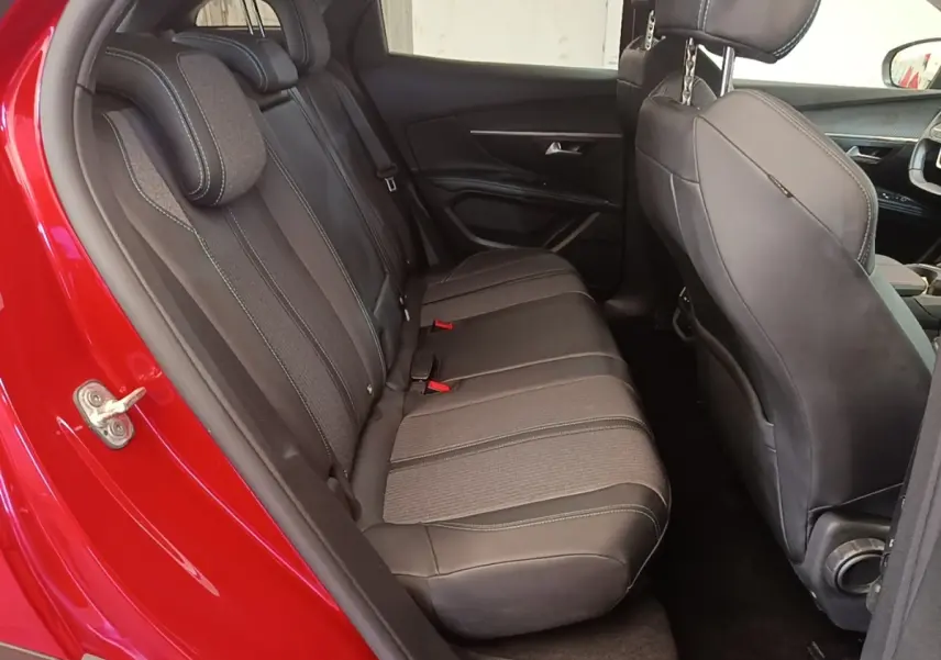 Vue intérieure côté gauche sur la banquette arrière grise du Peugeot 3008 PureTech 130 S&S Allure rouge, avec sièges en tissu et cuir.