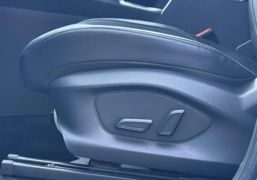 Gros plan sur les commandes de réglage électrique du siège avant en tissu/similicuir noir du MG ZS 1.5 Hybrid+ 197 Luxury.