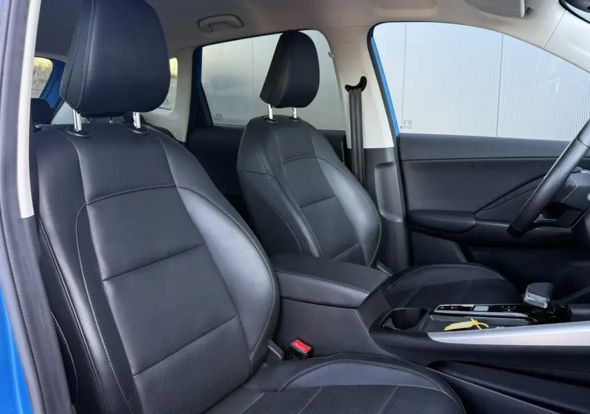Vue intérieure côté droit du MG ZS 1.5 Hybrid+ 197 Luxury 2025, sièges tissu/similicuir noir et accoudoir central.