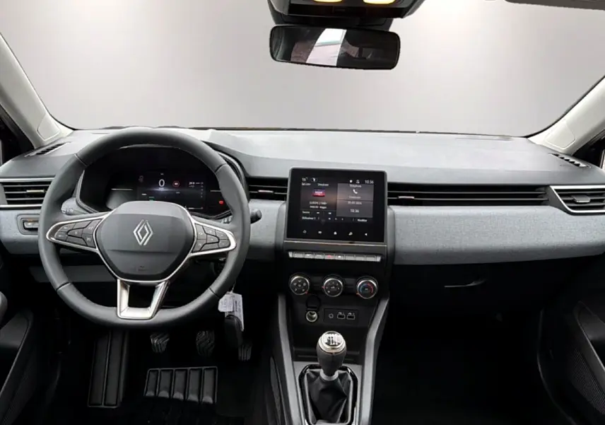 Vue intérieure avant de la Renault Clio V noire, montrant le volant multifonction et la console centrale avec écran tactile.