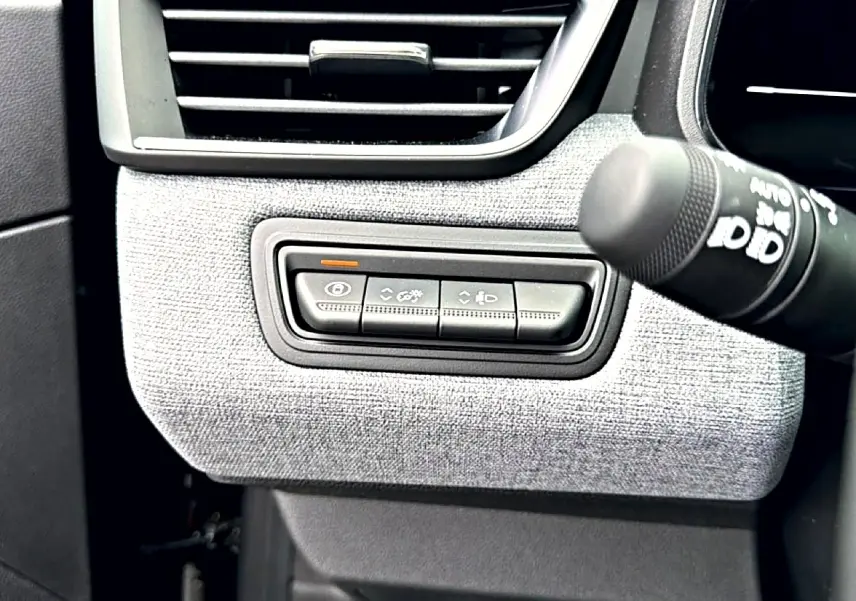 Détail intérieur côté gauche de la planche de bord de Renault Clio V noir, avec commandes d’éclairage et ventilation.