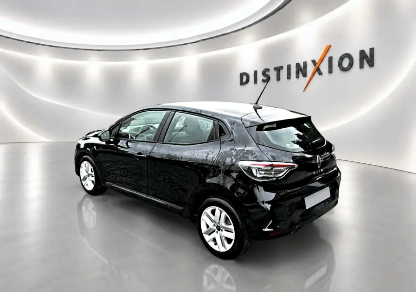 Vue 3/4 arrière droite d'une Renault Clio V noire avec feux LED et jantes argentées dans un showroom lumineux.