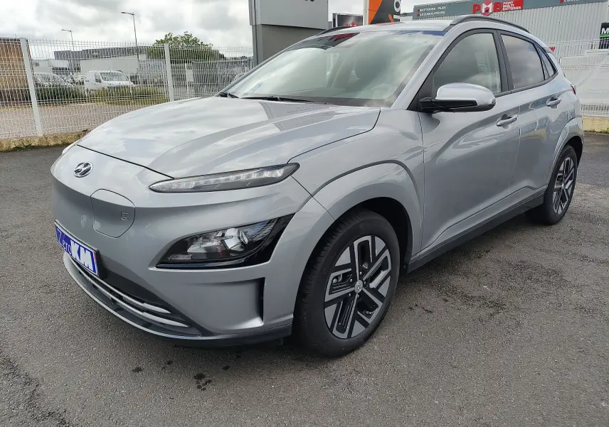 Vue 3/4 avant droite d'une Hyundai KONA Electric gris métallisé avec jantes alliage et calandre fermée.