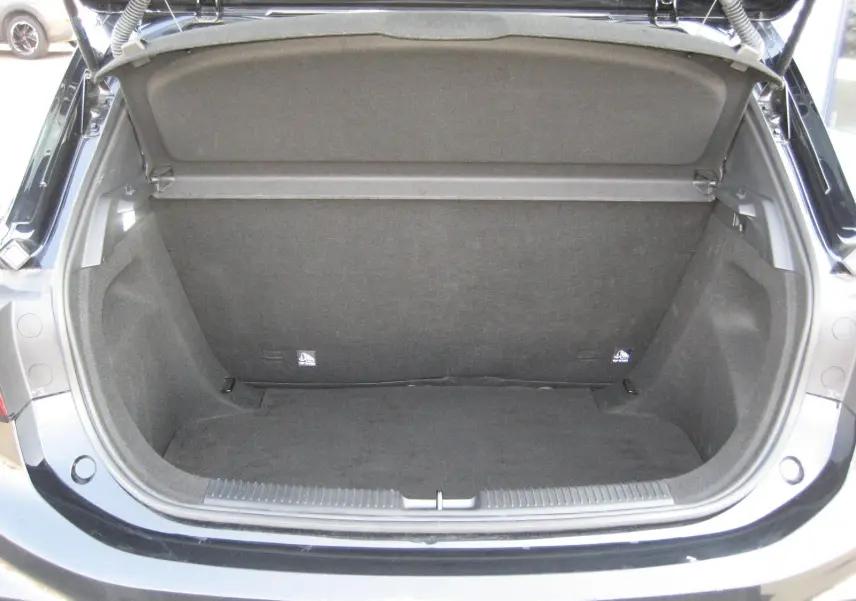 Coffre ouvert vu de l'arrière d'une MG MOTOR MG3 noire 2024, montrant un espace de chargement propre et vide.