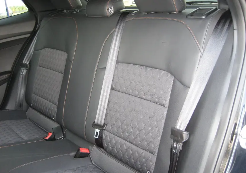 Vue rapprochée des sièges arrière noirs du MG3 2024 avec surpiqûres orange et ceintures de sécurité grises.