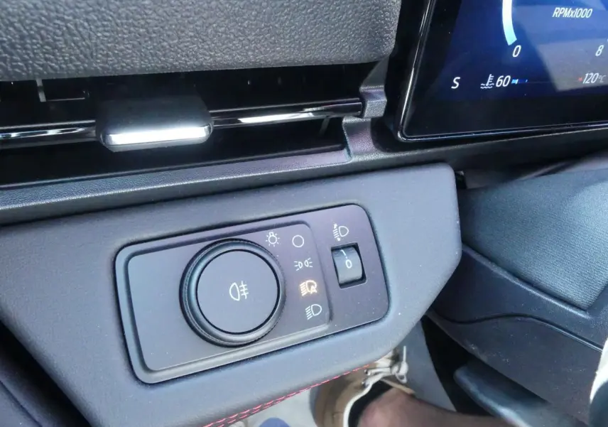 Gros plan sur la commande d'éclairage du tableau de bord du Ford Puma 2025 avec surpiqûres rouges visibles.