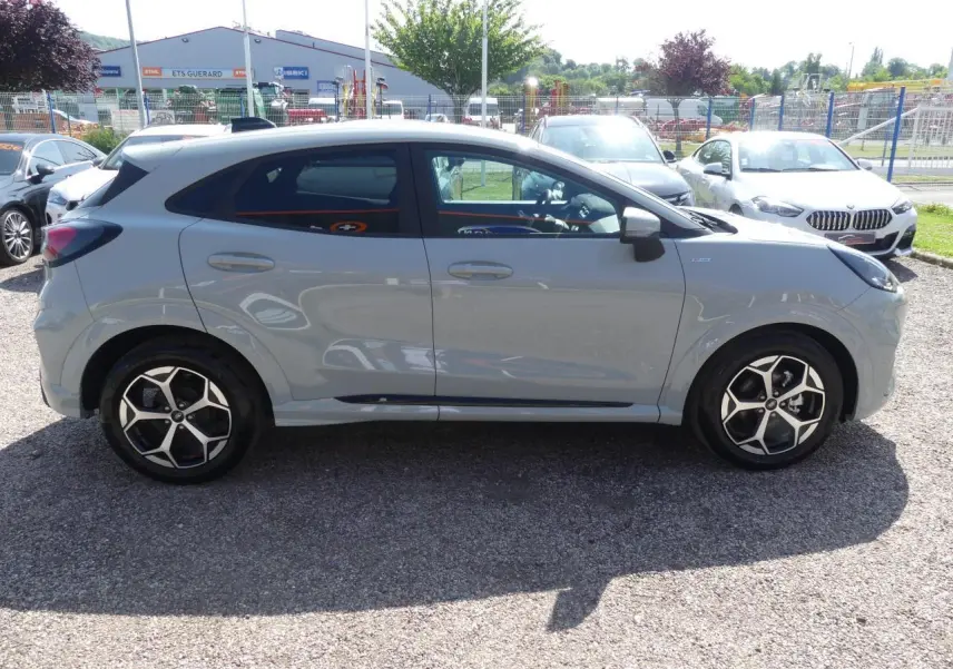 Ford Puma 2025 gris métallisé en vue profil côté gauche, avec jantes alliage 17 pouces et vitres arrière surteintées.