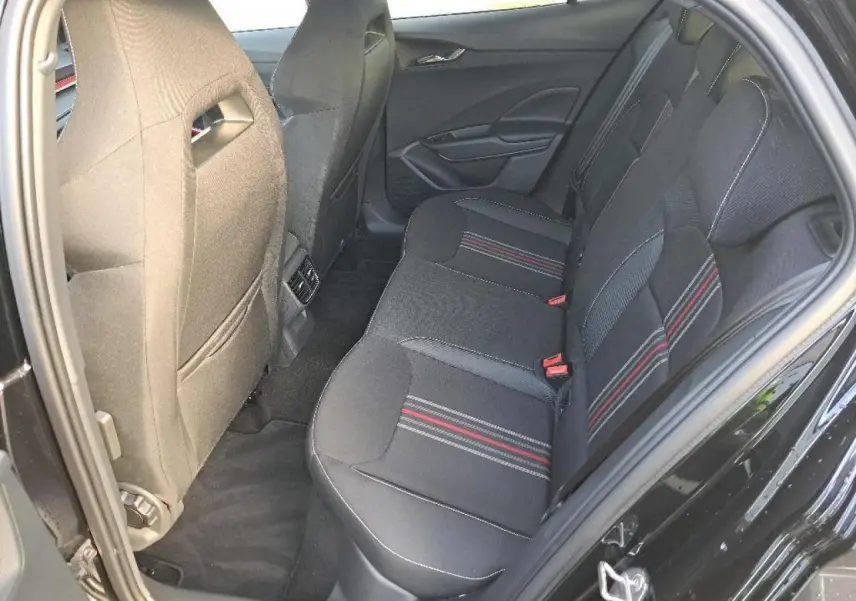 Vue intérieure côté droit des sièges arrière noirs avec surpiqûres rouges et grises d'une Skoda Fabia Monte Carlo 2024.