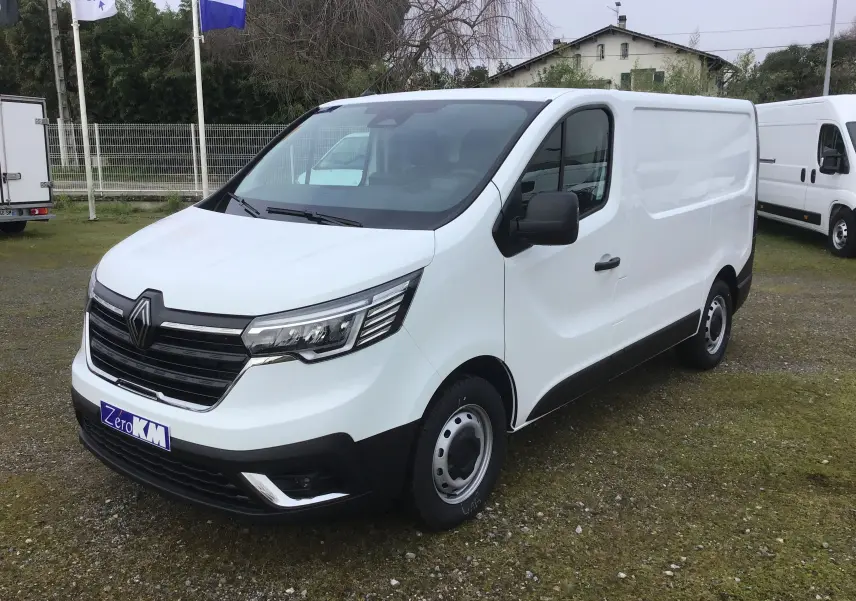 Renault Trafic Fourgon blanc vu en 3/4 avant droit, avec calandre noire et feux LED distinctifs.