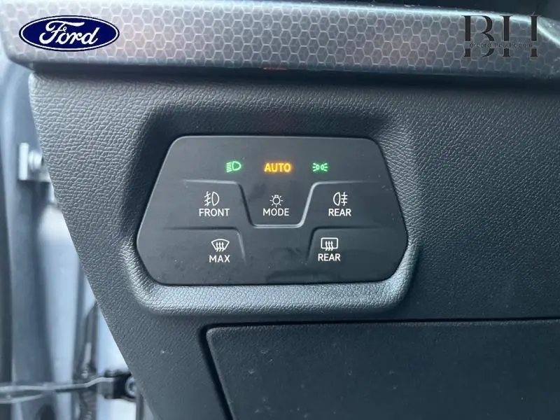 Panneau de commandes d'éclairage intérieur noir avec voyants verts et orange allumés, sur tableau de bord d'une SEAT LEON ST.