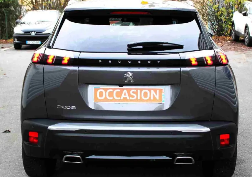 Vue arrière d'un Peugeot 2008 gris platinium avec feux arrière allumés et plaque d'occasion visible