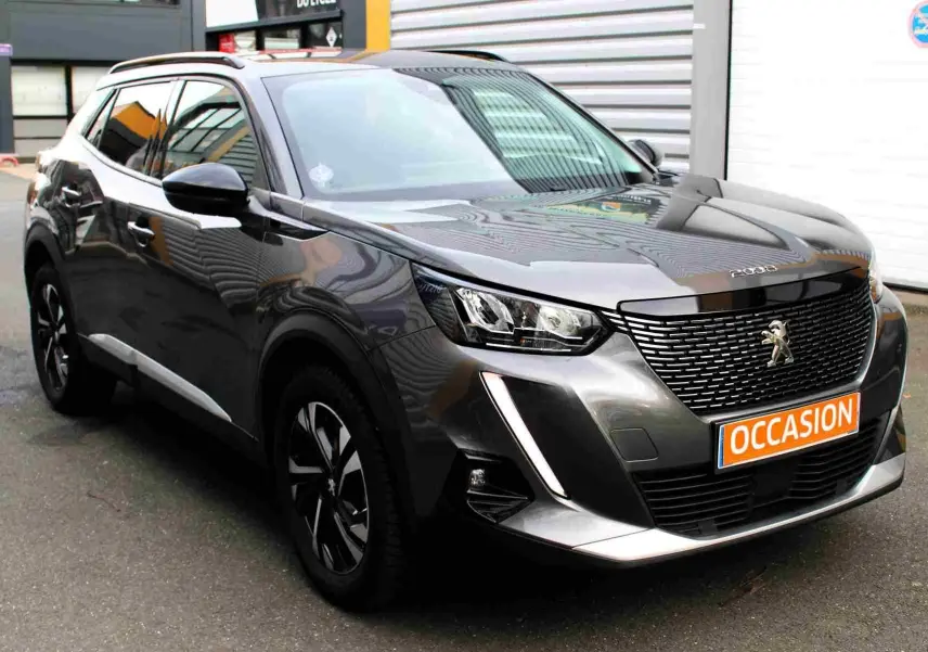 Peugeot 2008 gris platinium en 3/4 avant droit avec calandre noire et plaque "OCCASION" visible.
