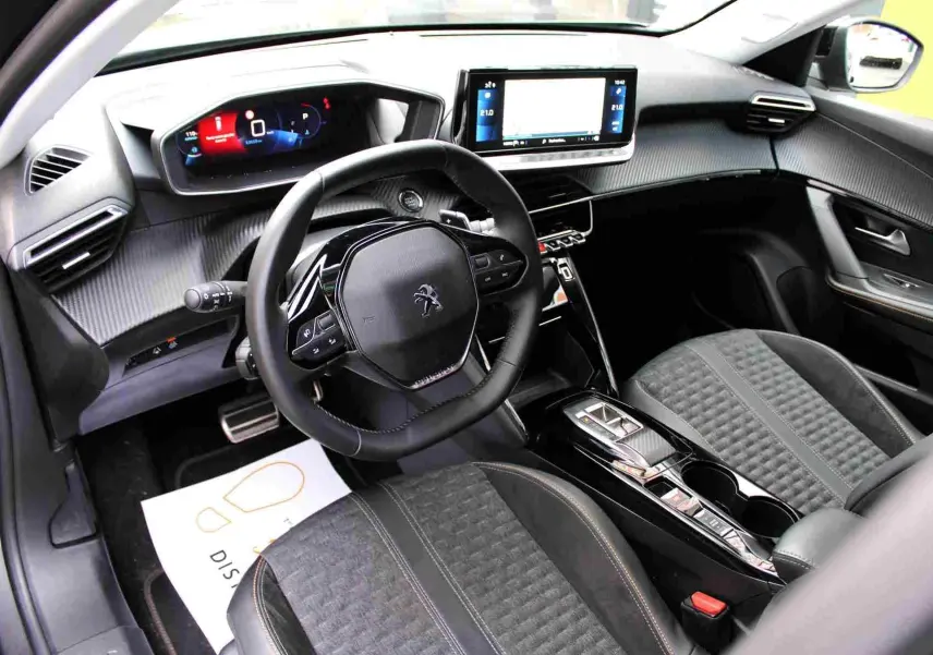 Intérieur du Peugeot 2008 II 1.2 PureTech 130 ch Roadtrip, vue côté conducteur sur tableau de bord et sièges noirs.