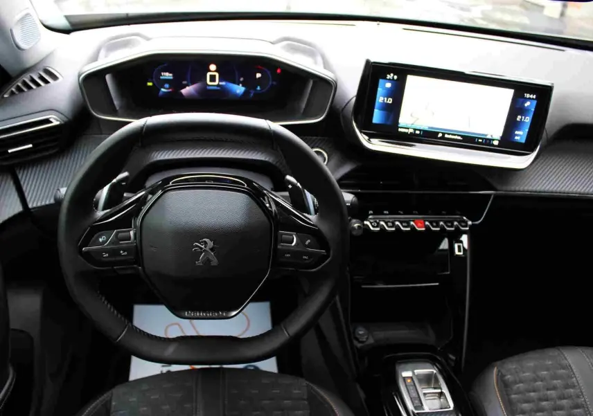Vue intérieure du tableau de bord et volant du Peugeot 2008 gris platinium avec écran tactile et commandes au volant.