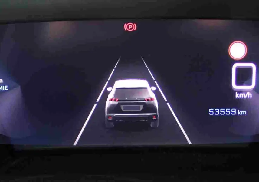 Affichage numérique du tableau de bord du Peugeot 2008 gris platinium, montrant une vue arrière stylisée du véhicule en stationnement.