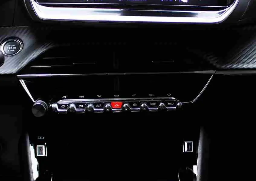 Tableau de bord de Peugeot 2008 II gris platinium, vue centrée sur l'écran tactile et les commandes de climatisation.