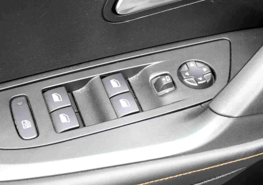 Gros plan sur les commandes des vitres et rétroviseurs côté conducteur du Peugeot 2008 gris platinium de 2022.