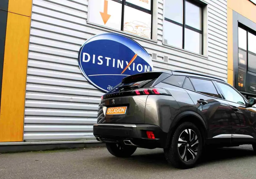 Peugeot 2008 gris platinium en 3/4 arrière droit, avec feux arrière à griffes et jantes noires bicolores.