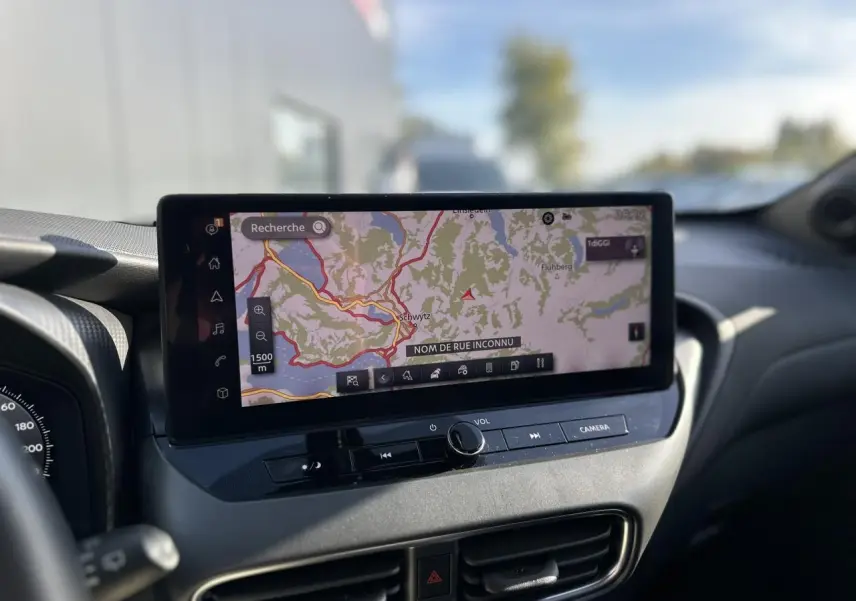Vue rapprochée de l’écran tactile central du Nissan Juke 2025 noir, affichant la navigation GPS en intérieur.
