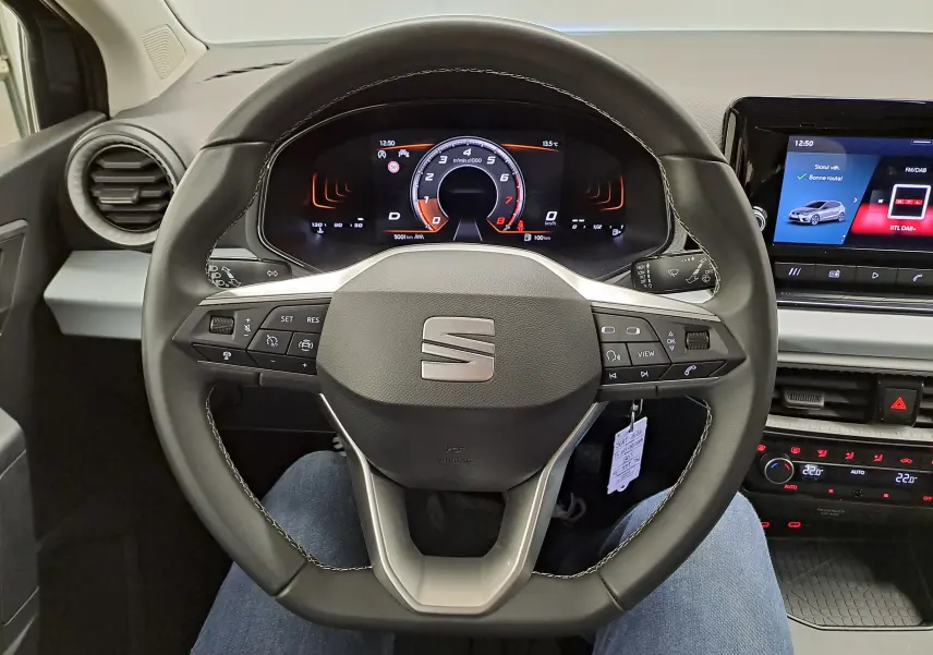 Vue intérieure centrée sur le volant multifonction de la SEAT Ibiza 2025 avec tableau de bord numérique et écran tactile.