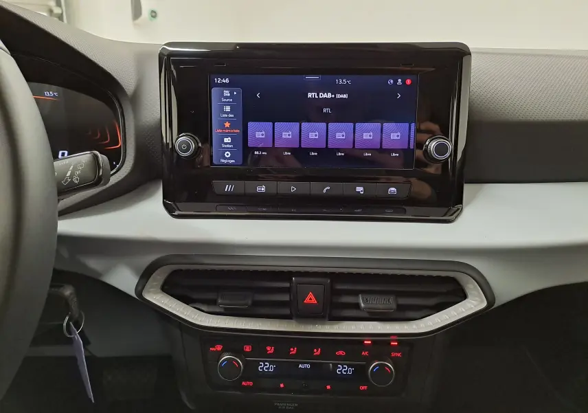 Vue intérieure centrée sur l’écran tactile et la console de climatisation de la SEAT Ibiza 1.0 TSI 115 DSG7 gris magnétique 2025.