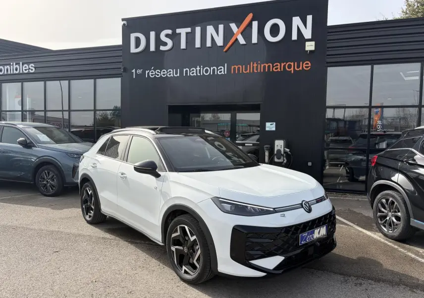 Volkswagen T-Roc blanc pur toit noir en 3/4 avant droit, avec jantes noires et calandre noire distinctive.