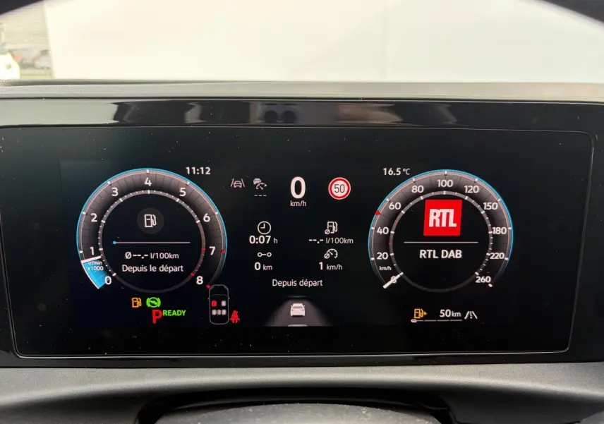 Tableau de bord numérique du Volkswagen T-Roc 2026 affichant vitesse, compte-tours et radio RTL en vue frontale.