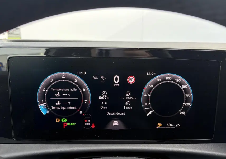 Affichage numérique du tableau de bord du Volkswagen T-Roc blanc, montrant les compteurs et informations de conduite.