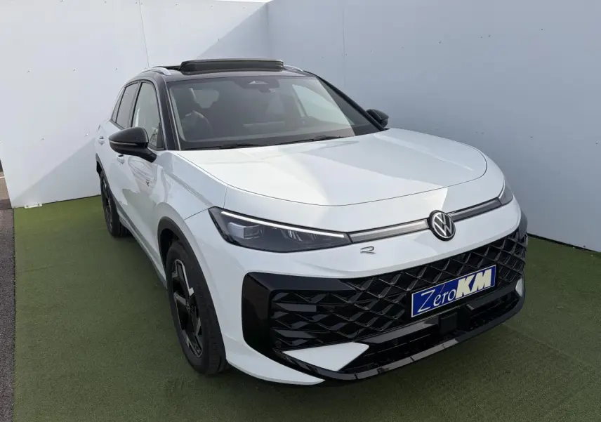 Volkswagen T-Roc blanc pur toit noir en vue 3/4 avant droit avec calandre noire et jantes noires distinctives.