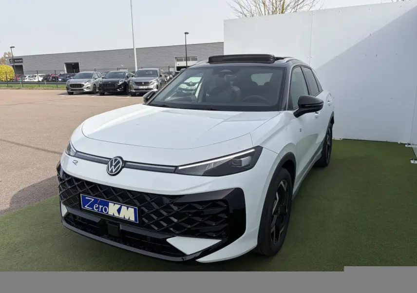 Volkswagen T-Roc blanc pur avec toit noir, vue 3/4 avant droit, calandre et jantes noires distinctives.
