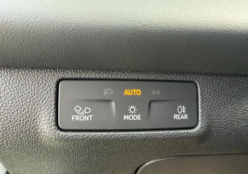 Panneau de commande d'éclairage automatique avec mode auto activé dans un Volkswagen T-Roc blanc toit noir.