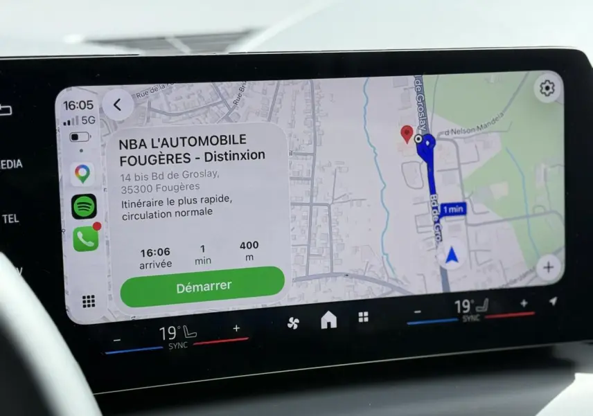 Écran tactile du système de navigation BMW Live Cockpit affichant un itinéraire avec commandes climatisation bi-zone en dessous.