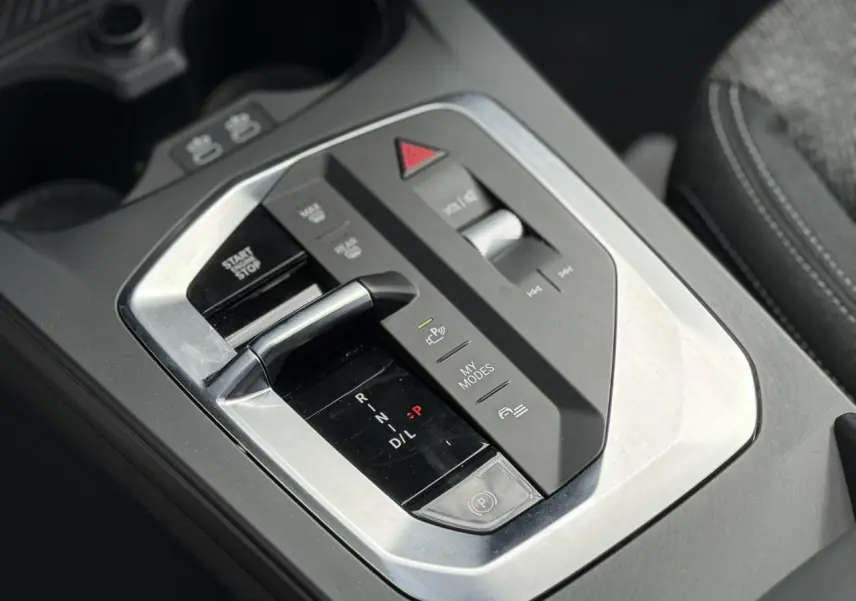 Gros plan sur la console centrale de la BMW Série 1 118d M Sport 2025, avec levier de boîte auto et commandes multifonctions.