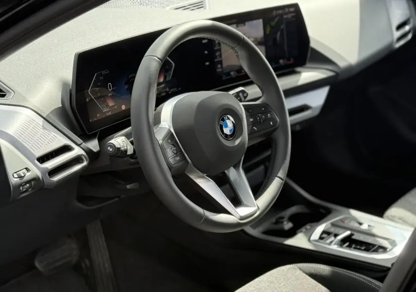 Vue intérieure du poste de conduite de la BMW Série 1 118d M Sport, volant multifonctions et écran digital.