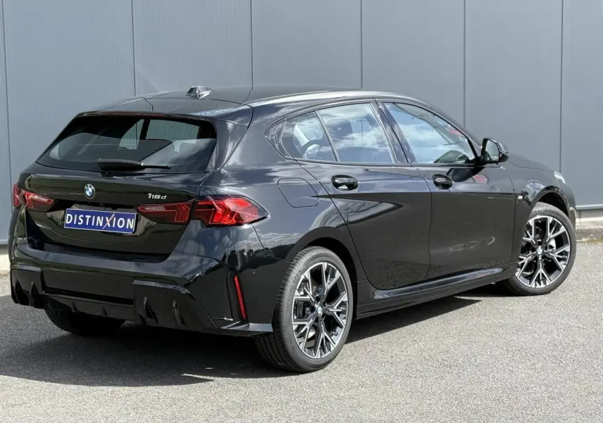 BMW Série 1 118d M Sport Saphirschwarz vue 3/4 arrière droit, jantes alliage 18 pouces et feux LED distinctifs.