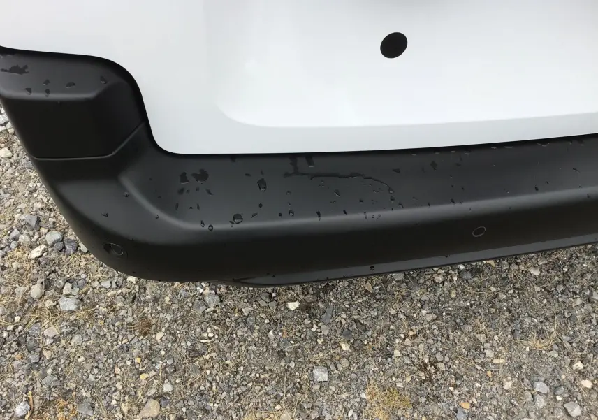Gros plan sur le pare-chocs arrière noir et blanc du Peugeot Partner XL 2026, avec capteurs de recul visibles.