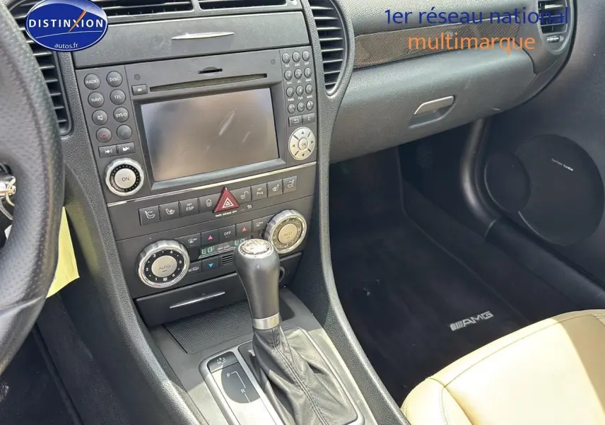 Intérieur côté passager d'une Mercedes SLK 55 AMG 2009, avec sellerie cuir beige et tapis AMG noir.
